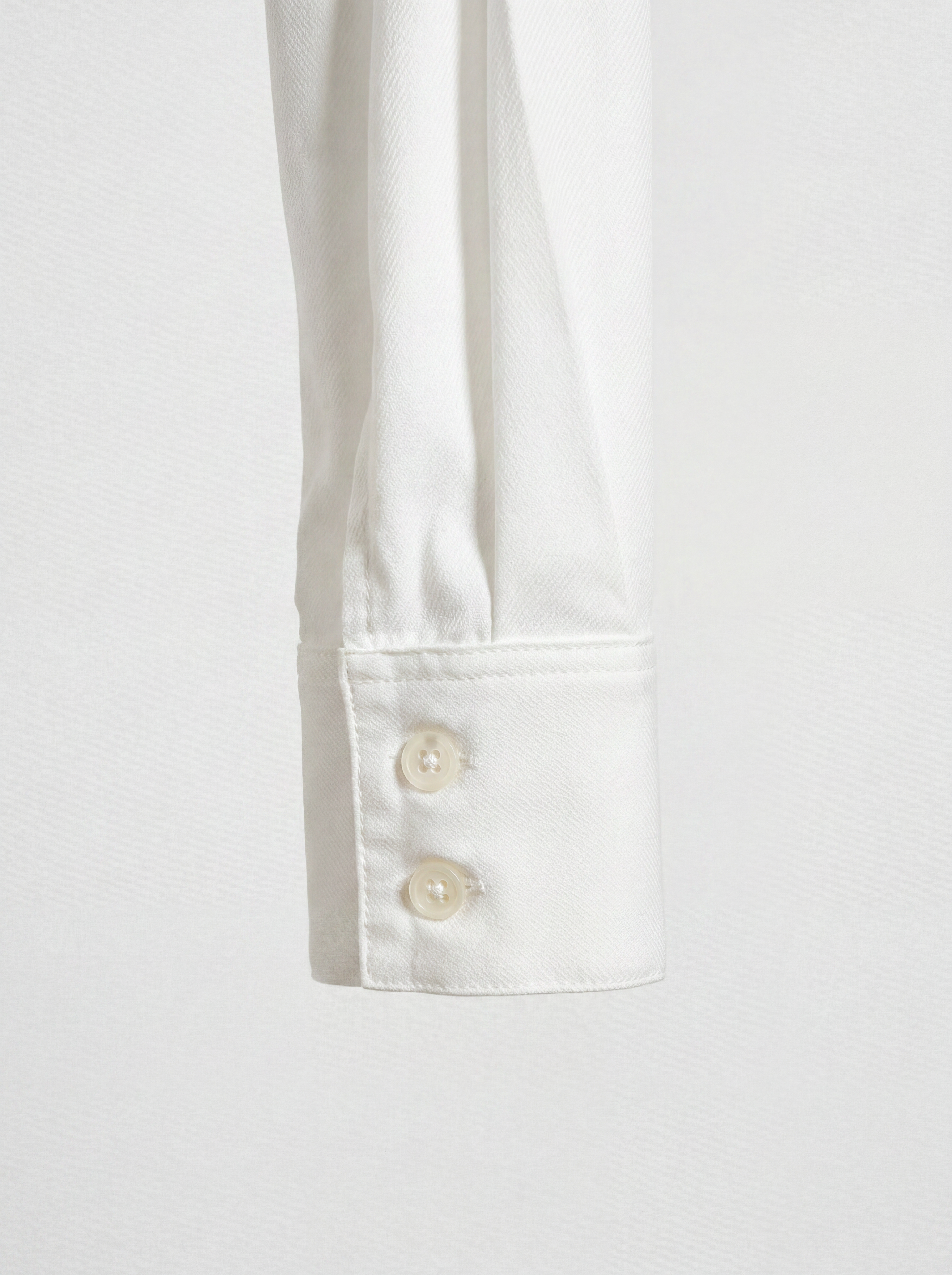 Close-up of LA CAMICIA OTTANTA by ORNELLA COLICCHIO highlighting the cuff construction, precise stitching and two buttons