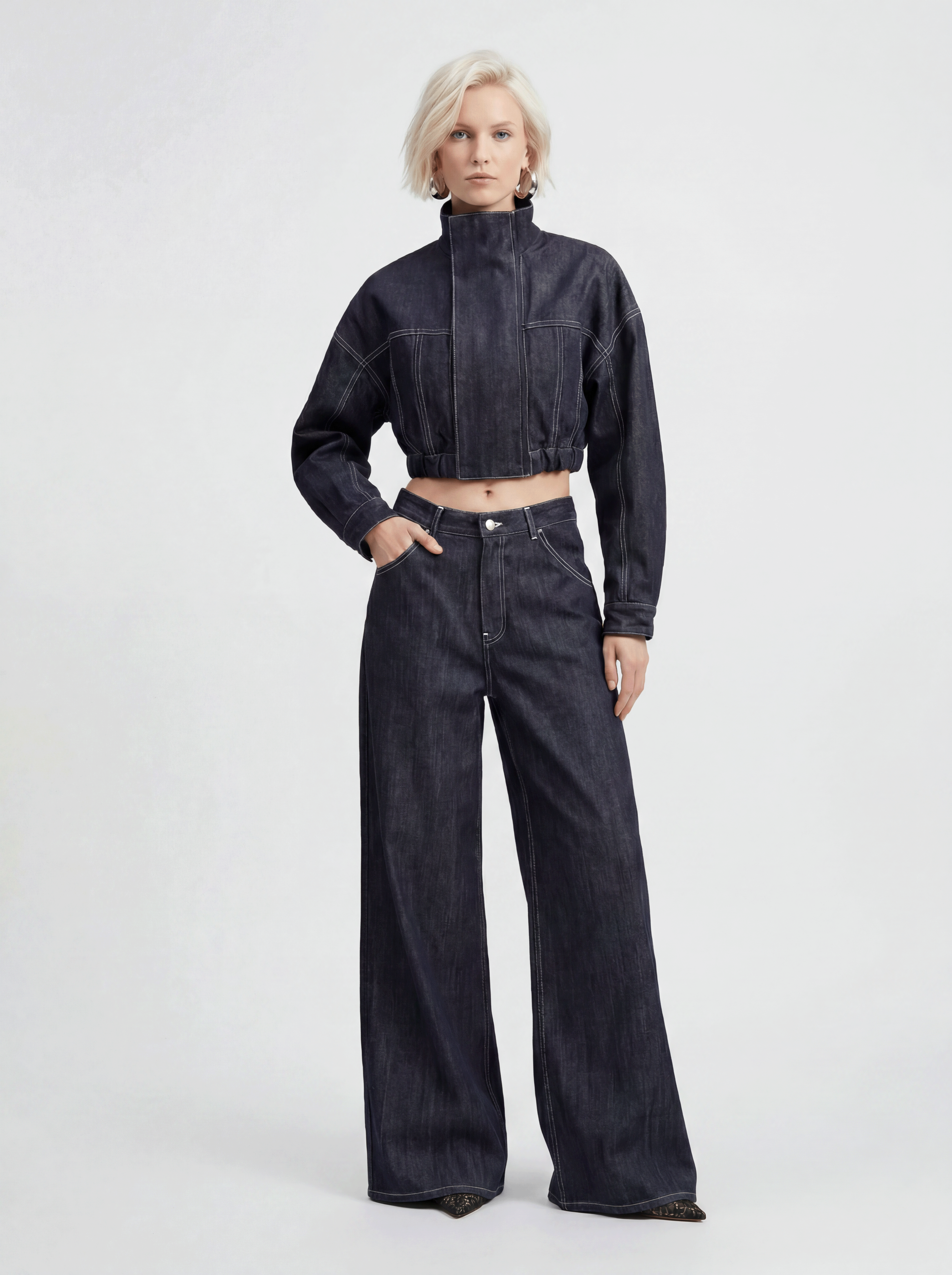 Front view of model wearing LA GIACCA CORTA IN DENIM and IL DENIM TRIANGOLO by ORNELLA COLICCHIO, looking directly into the camera and showing the cropped denim jacket with Triangolo jeans