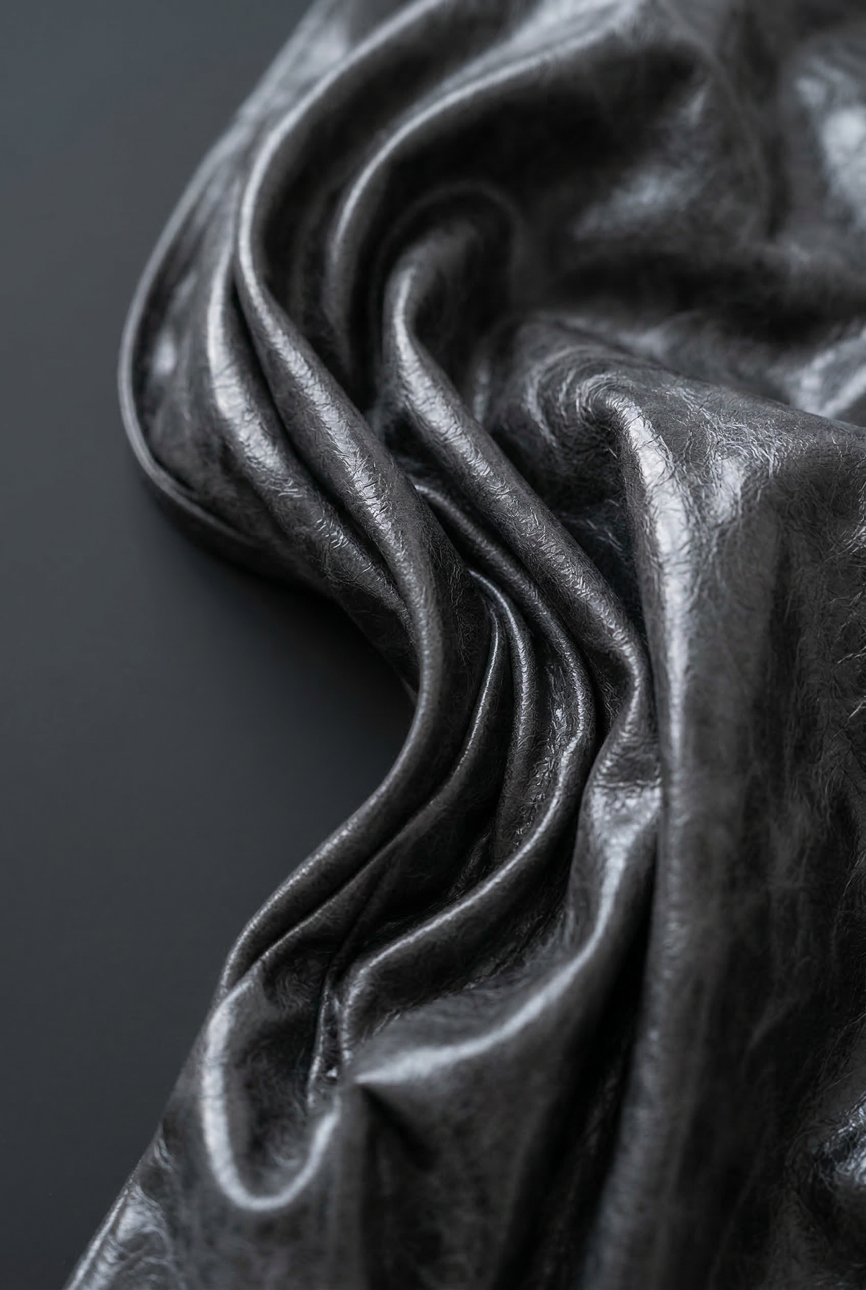 Close-up of LA GIACCA CORTA SCULTURA by ORNELLA COLICCHIO showing the smooth material surface against a black background