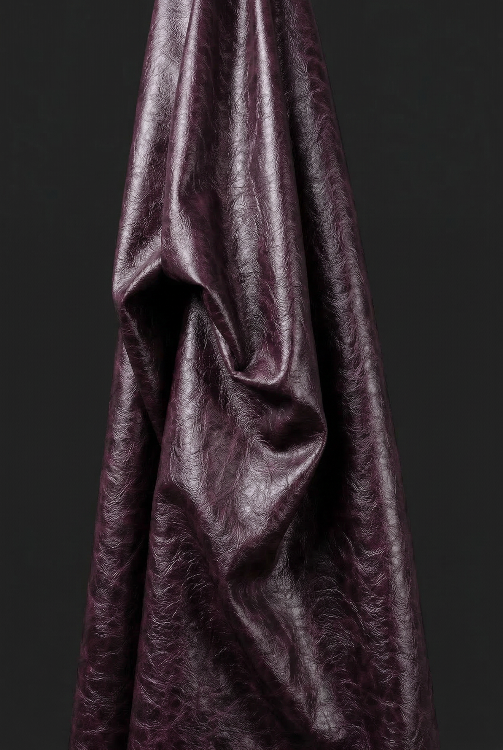Close-up of LA GIACCA CORTA BORDEAUX by ORNELLA COLICCHIO showing the smooth bordeaux material surface against a black background