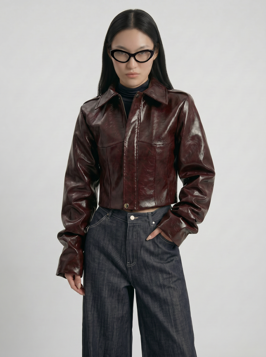 Front view of model wearing LA GIACCA CORTA BORDEAUX with sculptural sleeves and IL DENIM TRIANGOLO by ORNELLA COLICCHIO, one hand in the jeans and looking into the camera