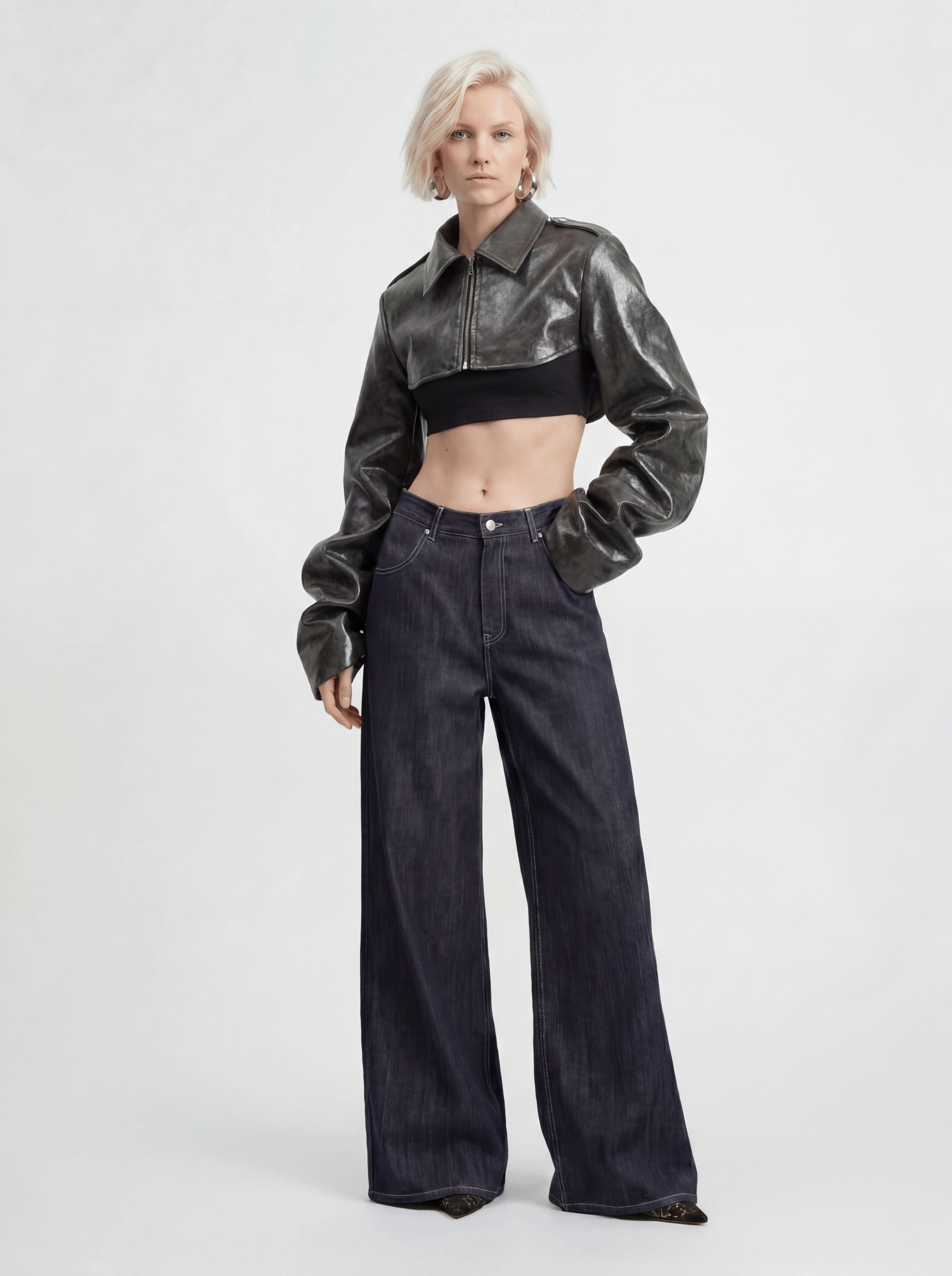 Front view of model wearing LA GIACCA CORTA SCULTURA by ORNELLA COLICCHIO with IL DENIM TRIANGOLO, slightly turning the upper body and looking into the camera, with focus on the collar and sculptural sleeves